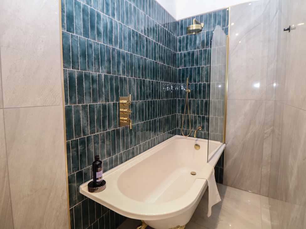A bathroom with bathtub and shower features at The Haddon Suite in Buxton