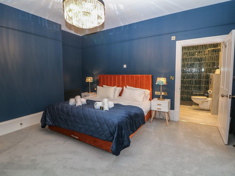 A bedroom with a bed and adjoining bathroom at The Haddon Suite in Buxton