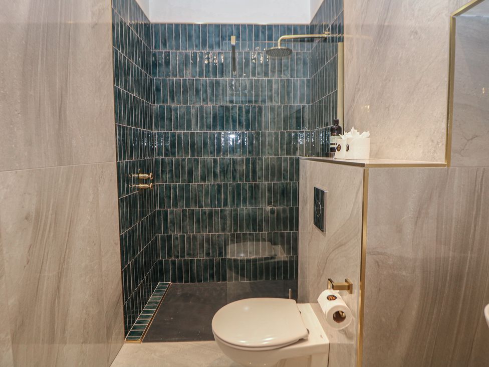 A bathroom with a shower and toilet at The Haddon Suite in Buxton