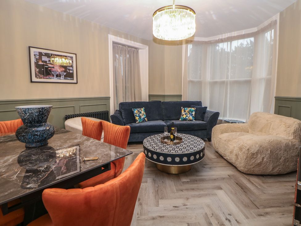 A living room with a sofa, armchair, and coffee table at The Chatsworth Suite in Buxton