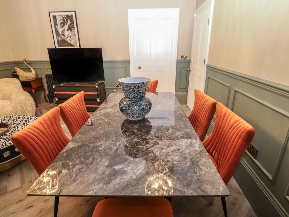 A dining room with a table and chairs at The Chatsworth Suite in Buxton