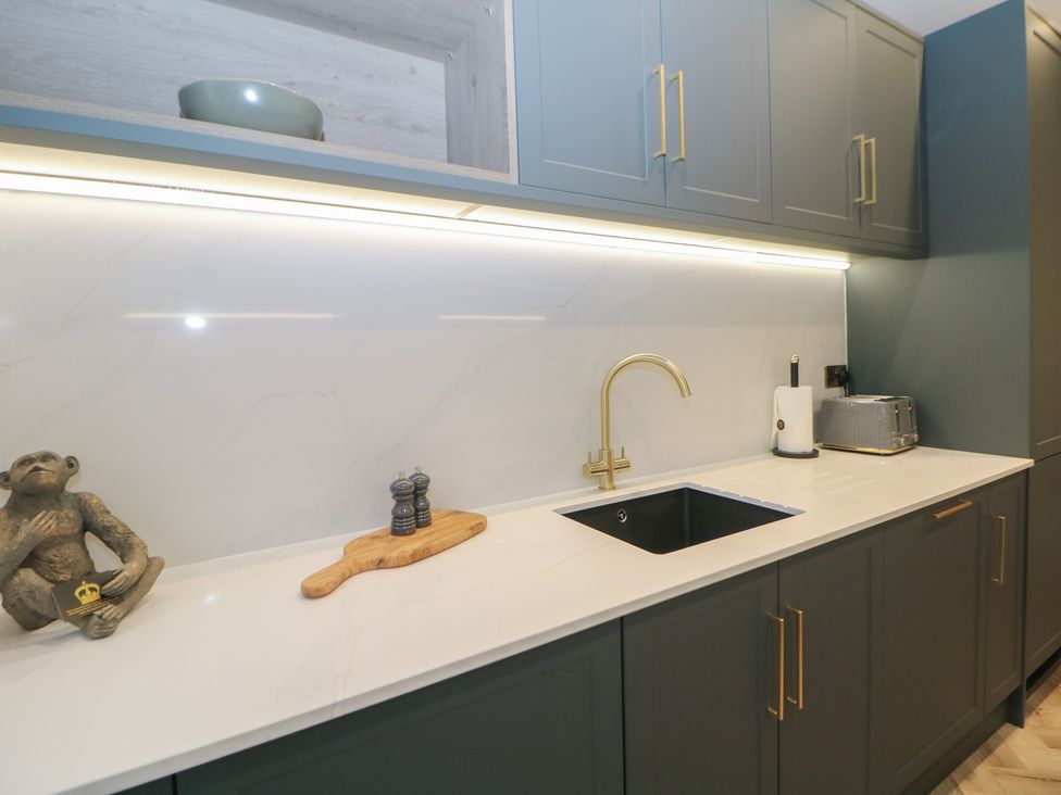 A kitchen with a sink and kitchen cabinets at The Chatsworth Suite in Buxton