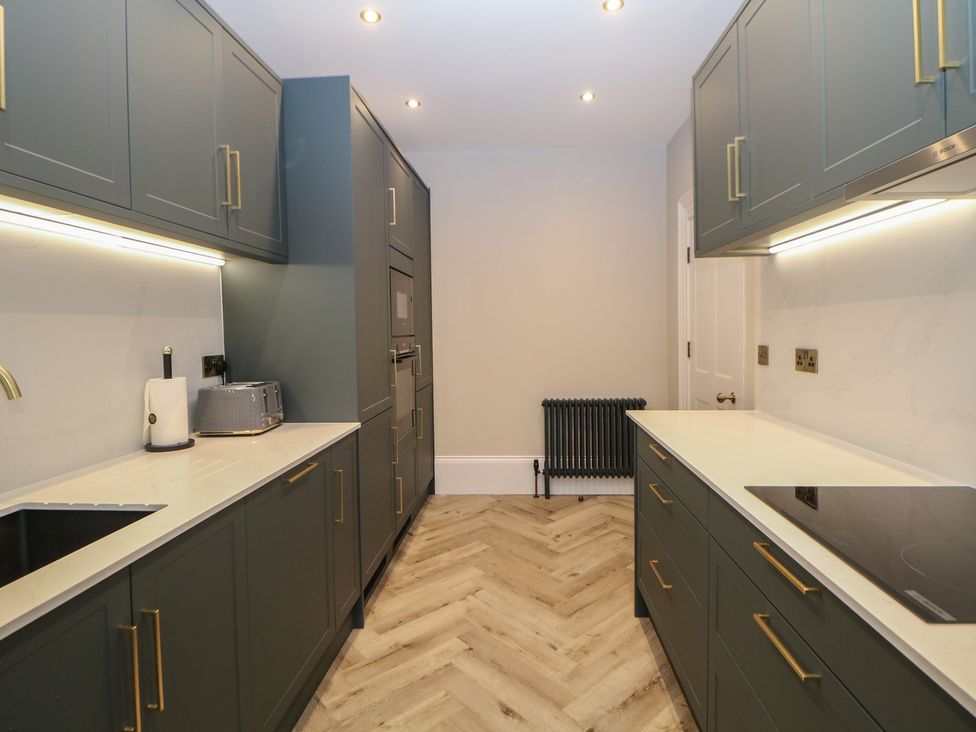 A kitchen with cabinets and appliances at The Chatsworth Suite in Buxton