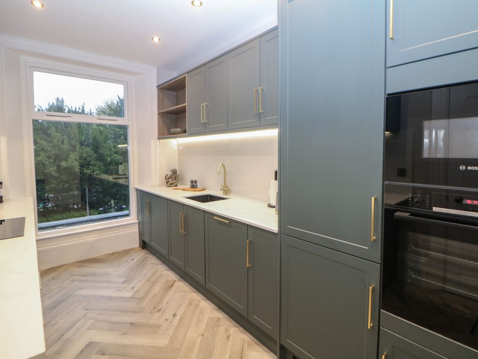 A kitchen with cabinets and a sink at The Chatsworth Suite Buxton