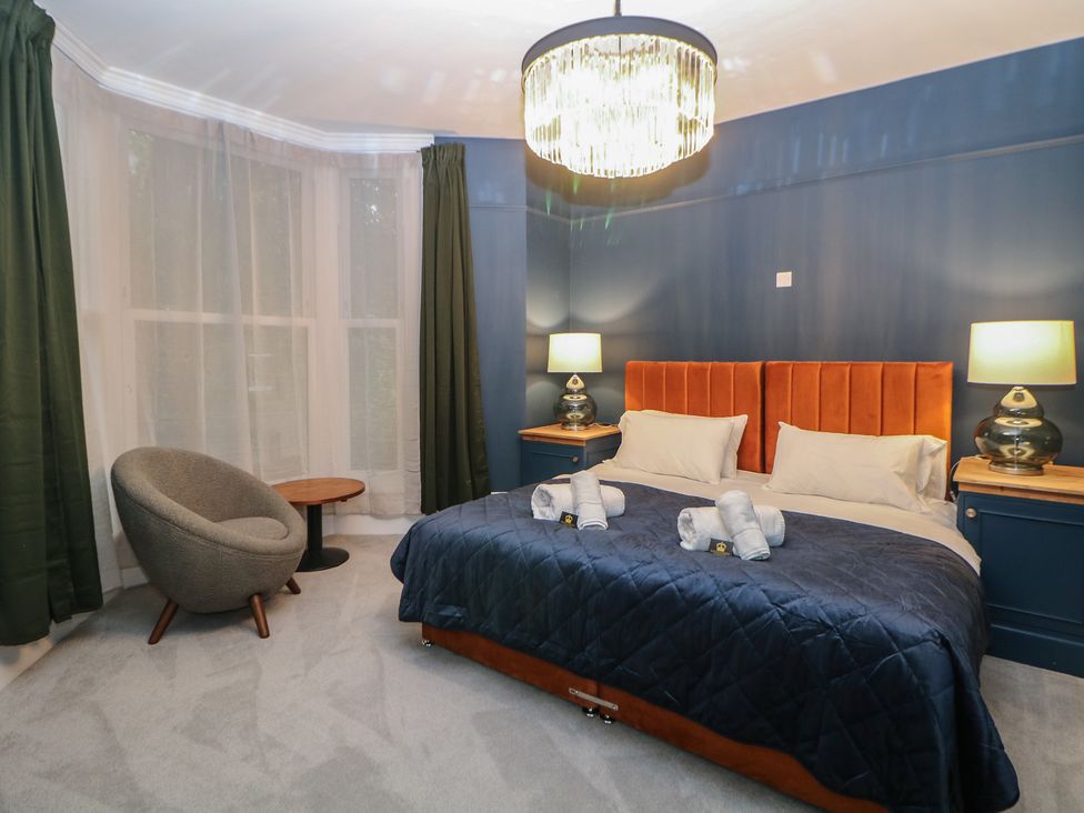 A bedroom with a bed and armchair at The Chatsworth Suite in Buxton