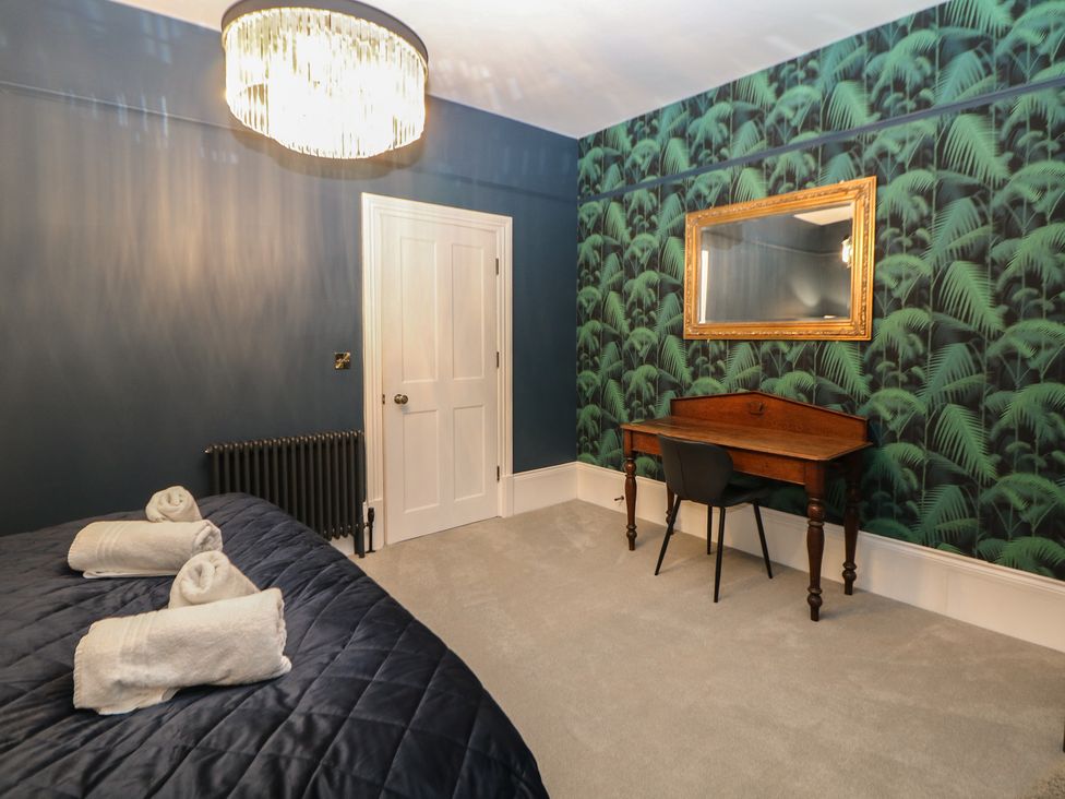 A bedroom with a bed and a desk at The Chatsworth Suite in Buxton