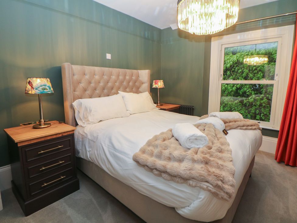 A bedroom with a bed and nightstand at The Chatsworth Suite Buxton