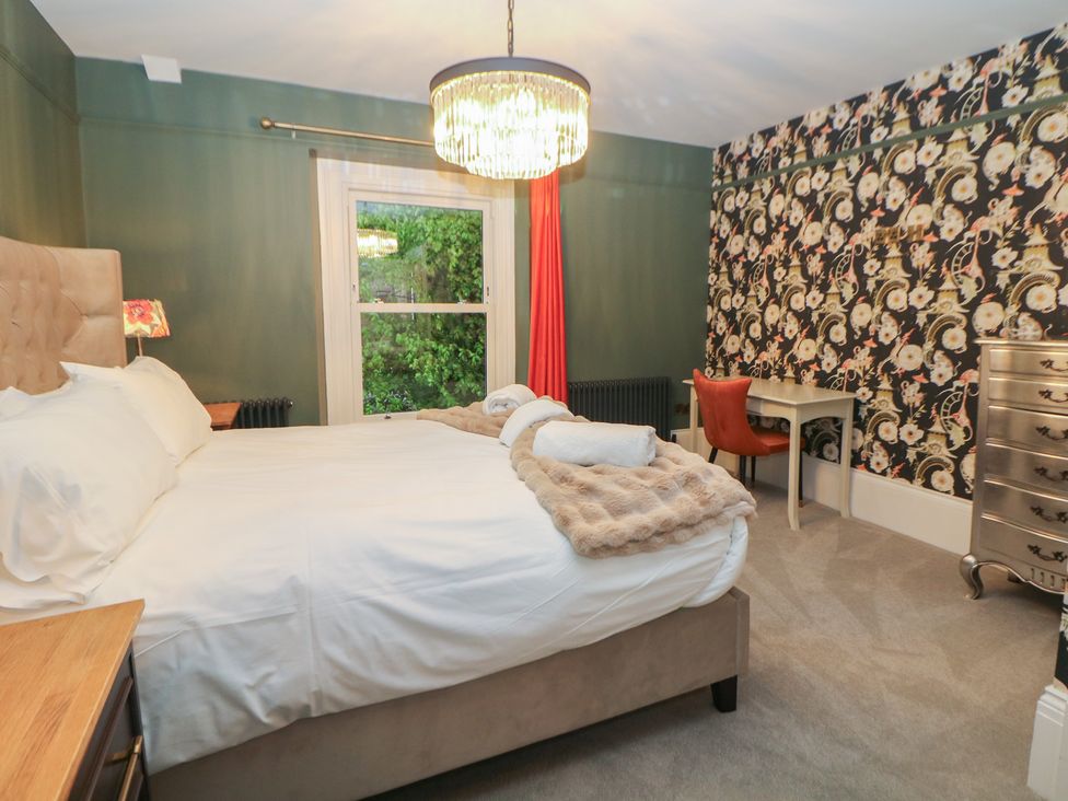 A bedroom with a bed and desk at The Chatsworth Suite in Buxton