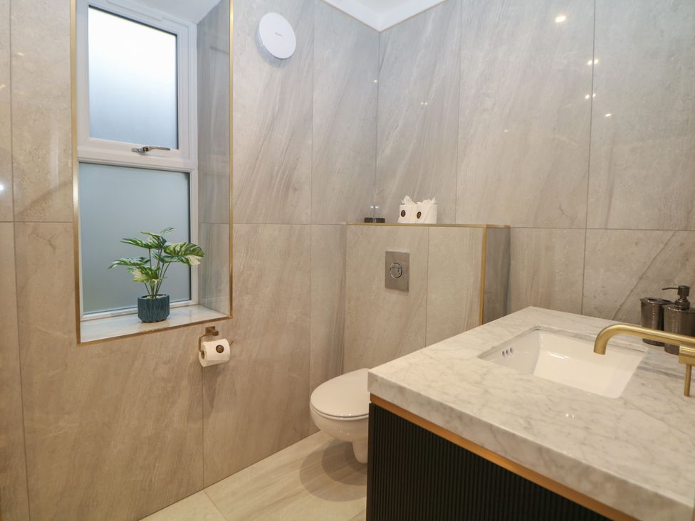 A bathroom with a sink and toilet at The Chatsworth Suite in Buxton
