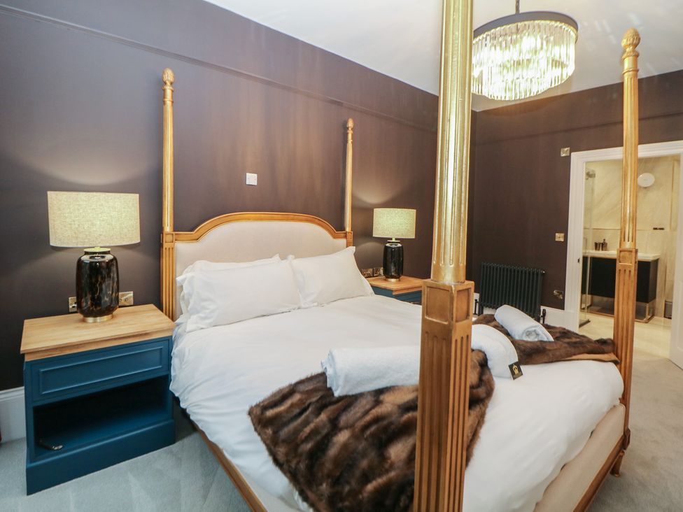 A bedroom with a four-poster bed and nightstands at The Chatsworth Suite in Buxton