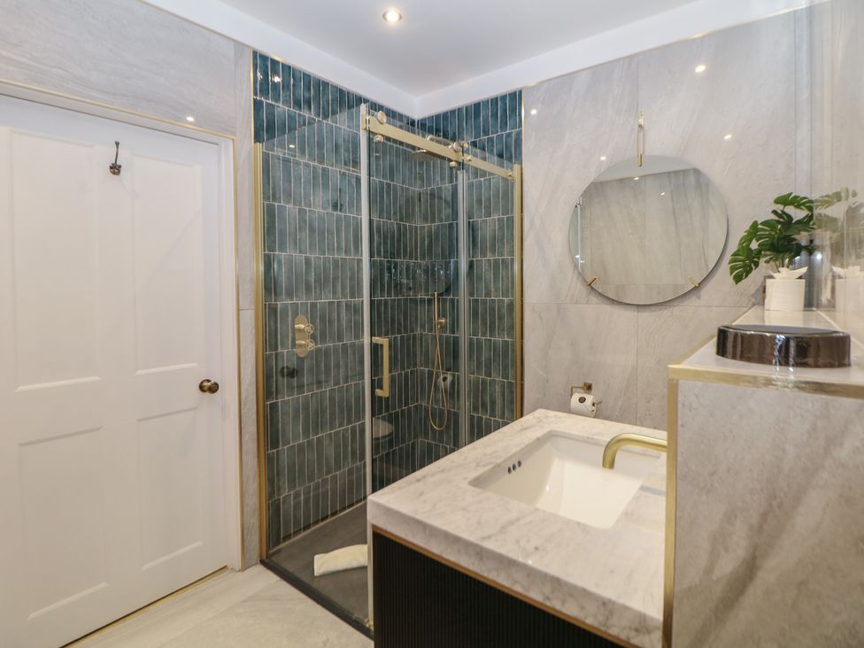 A bathroom with a shower and sink at The Chatsworth Suite in Buxton