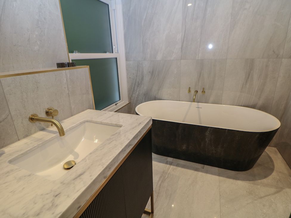 A bathroom with a sink and bathtub at The Chatsworth Suite Buxton