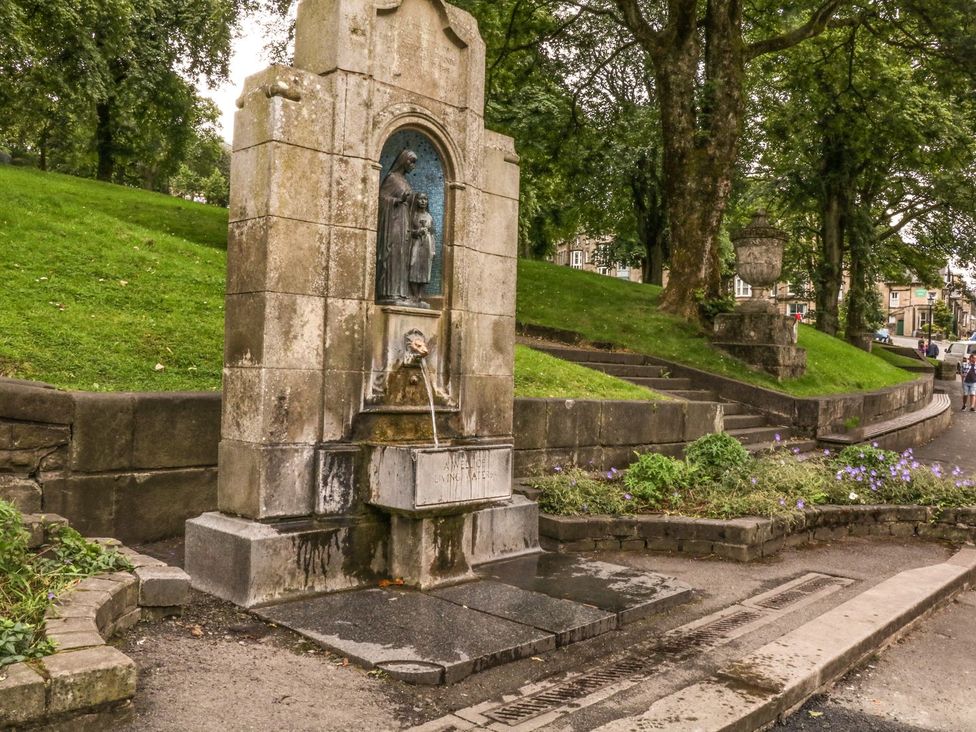 A fountain with a statue surrounded by greenery at The Chatsworth Suite in Buxton