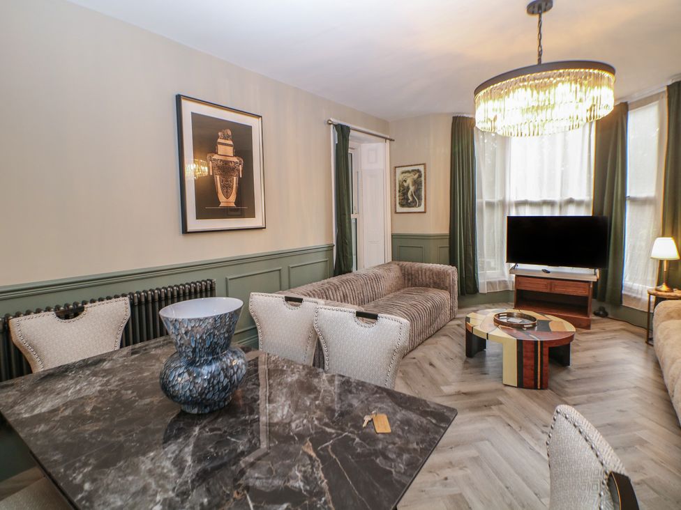 A living room with a television and sofa at The Devonshire Suite in Buxton