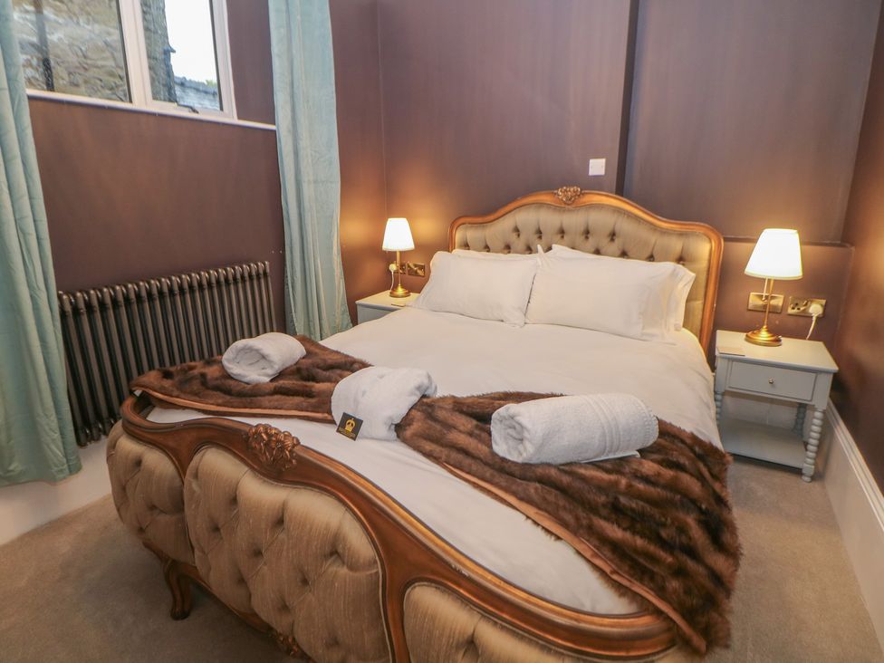 A bedroom with a double bed and bedside table at The Devonshire Suite in Buxton