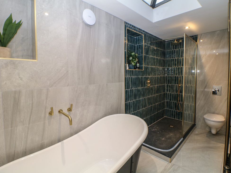 A bathroom with a bathtub and shower at The Devonshire Suite in Buxton