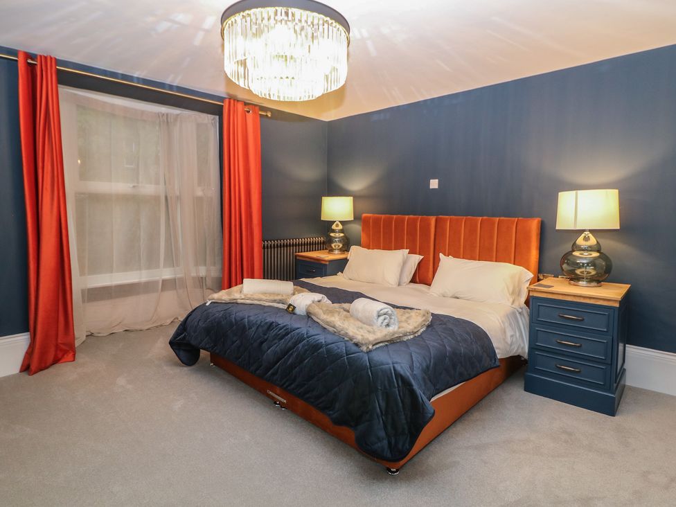A bedroom with a bed and bedside tables at The Devonshire Suite in Buxton