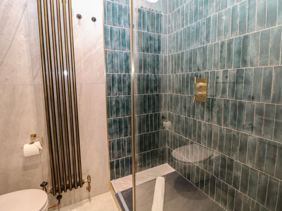A bathroom with a shower and toilet in The Devonshire Suite Buxton