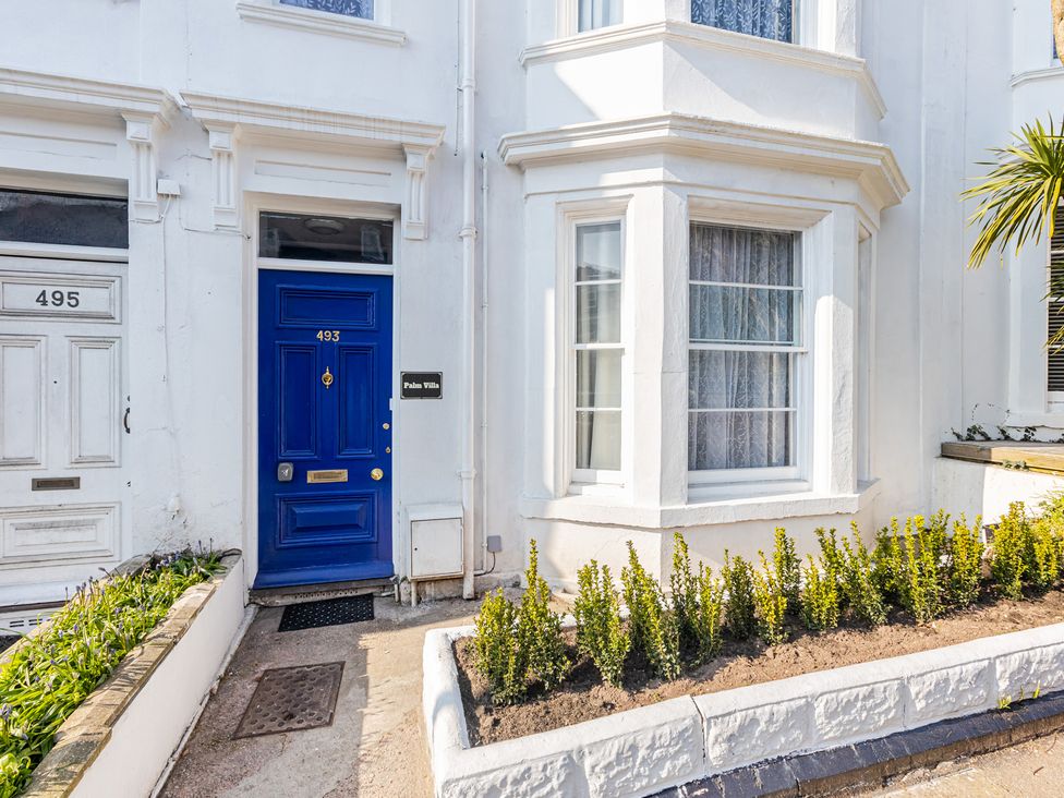 A blue door with a sign at Palm Villa in Torquay