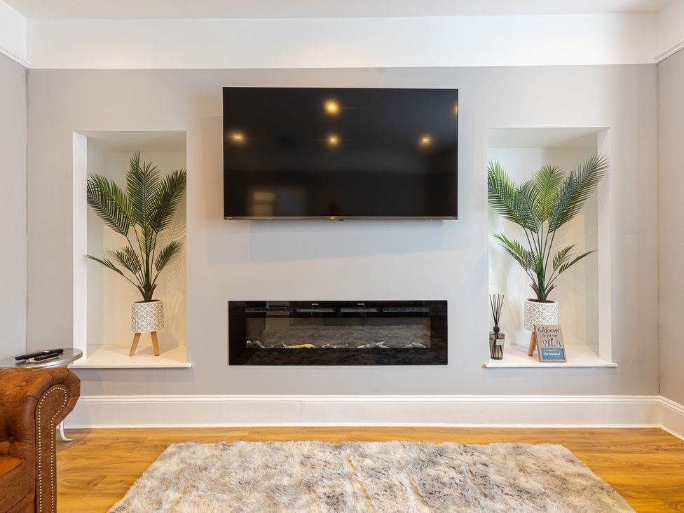 A living room with a television and fireplace at Palm Villa in Torquay