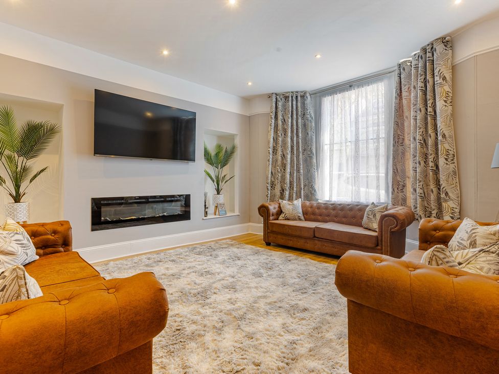 A living room with a television and fireplace at Palm Villa in Torquay