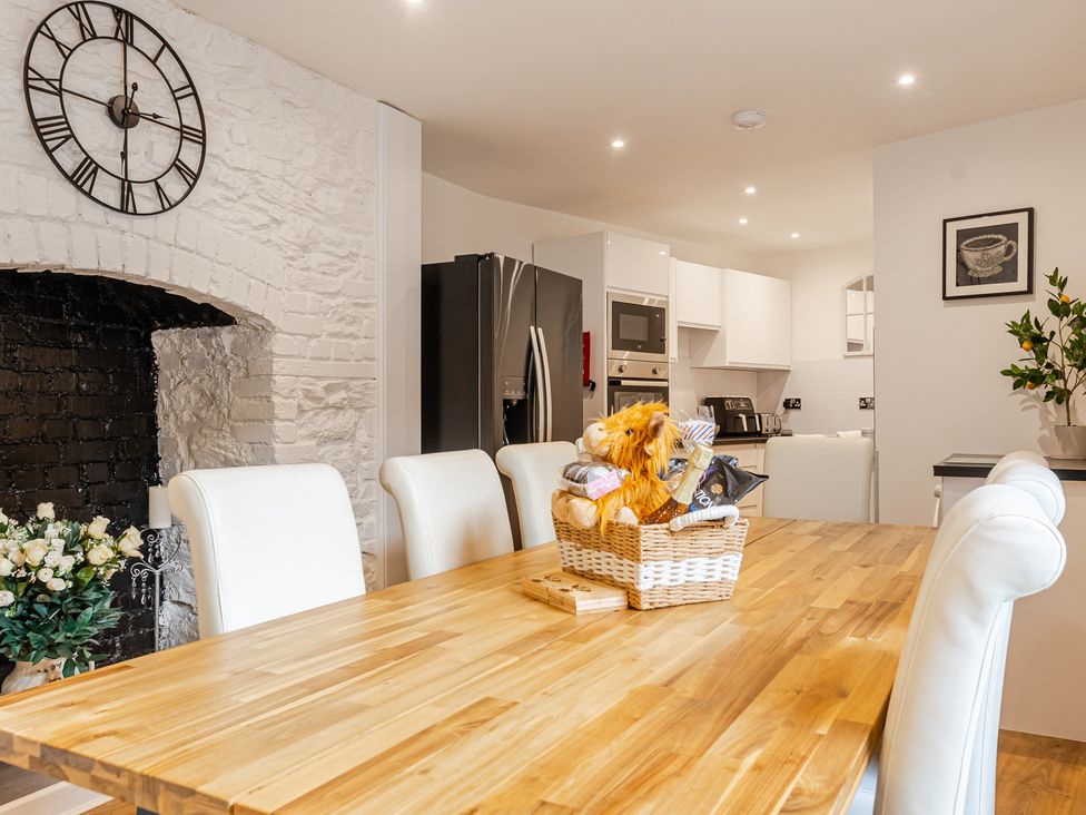 A dining room with a wooden table and chairs at Palm Villa in Torquay