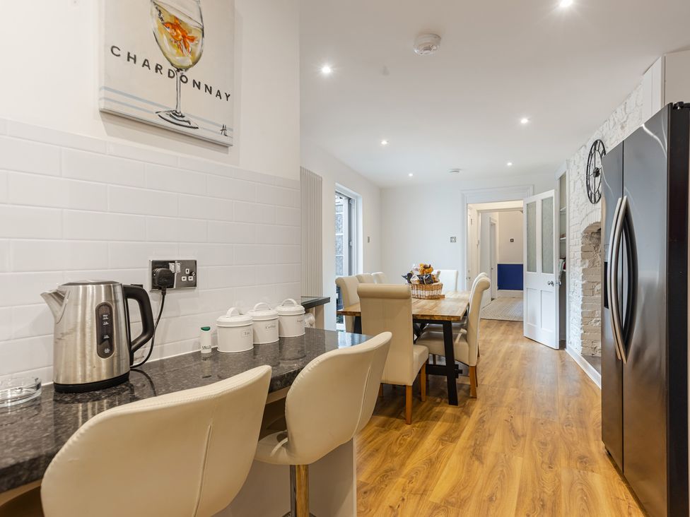A kitchen with a dining table and chairs at Palm Villa in Torquay