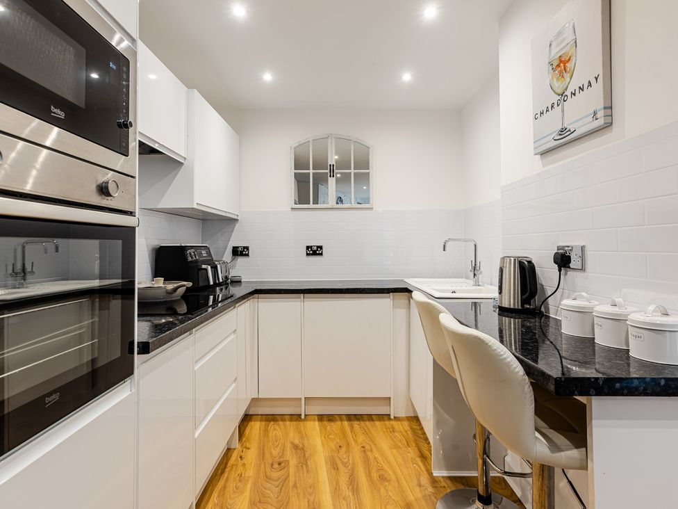 A kitchen with appliances and seating at Palm Villa in Torquay