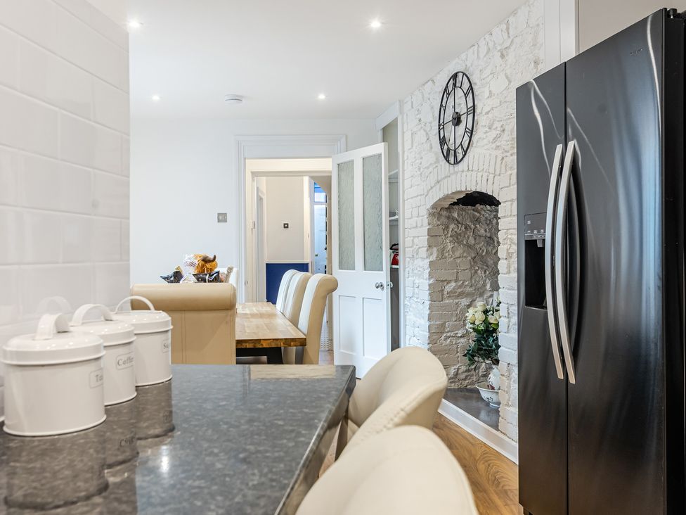 A kitchen featuring a refrigerator and a table at Palm Villa in Torquay