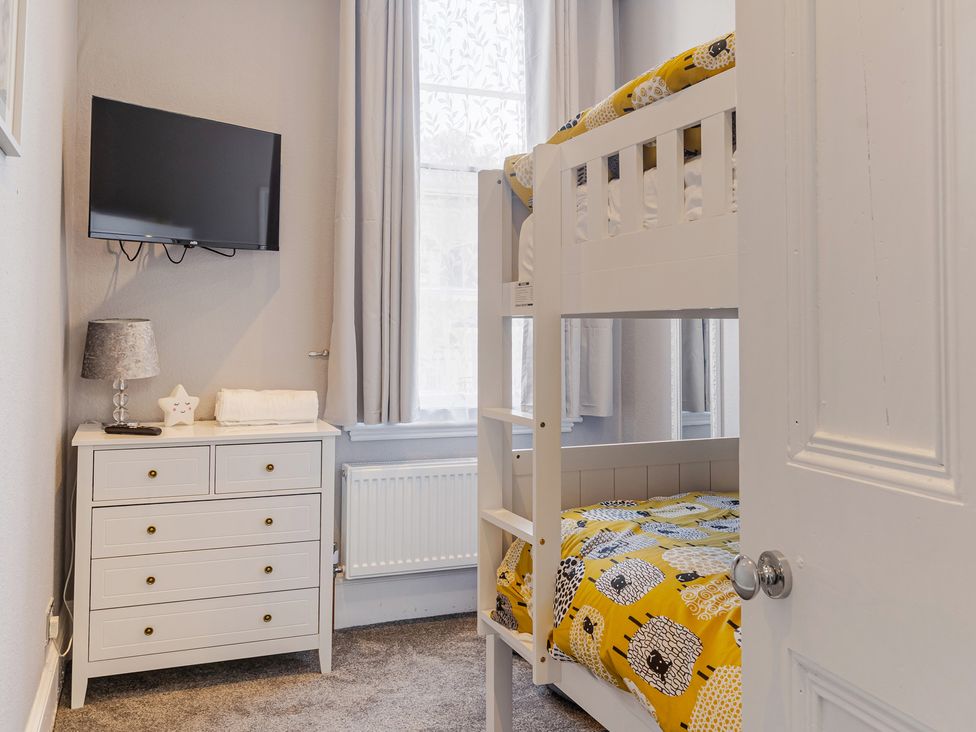 A bedroom with a bunk bed and TV at Palm Villa in Torquay