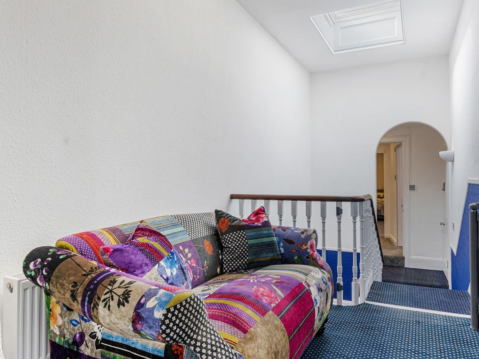 A hallway with a sofa and skylight at Palm Villa in Torquay