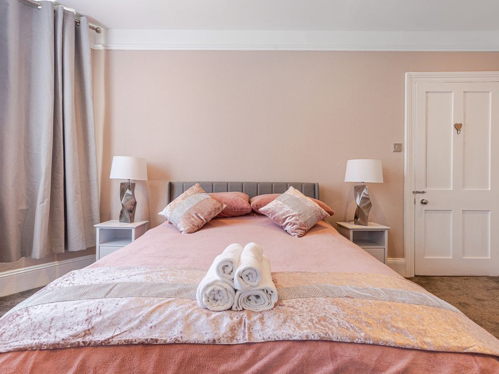 A bedroom with a bed and bedside tables at Palm Villa in Torquay