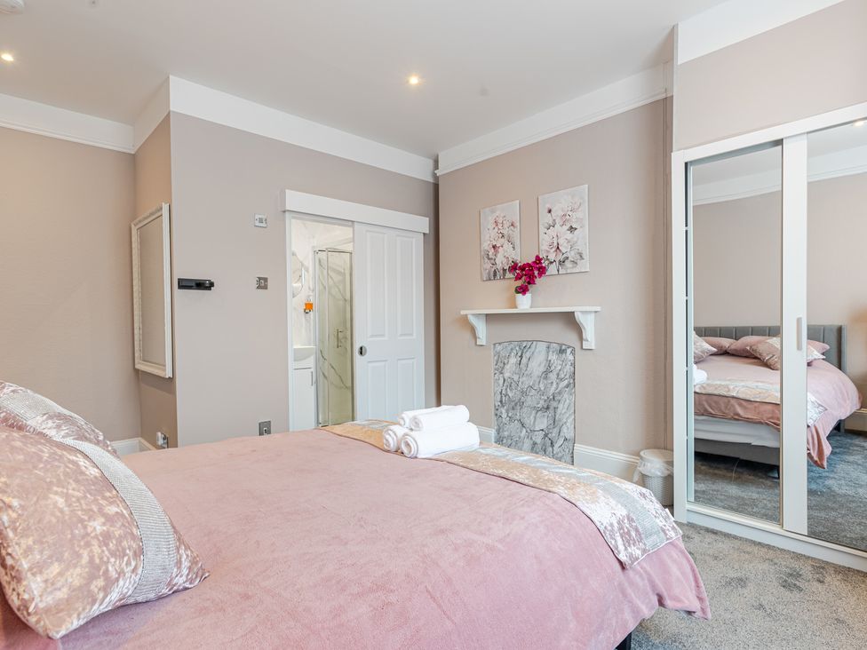 A bedroom with a bed and a bathroom door at Palm Villa in Torquay