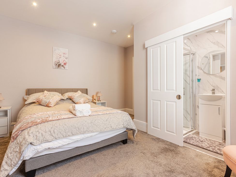A bedroom featuring a bed and an adjoining shower area at Palm Villa in Torquay