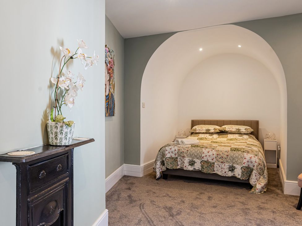 A bedroom with a bed and nightstand at Palm Villa in Torquay