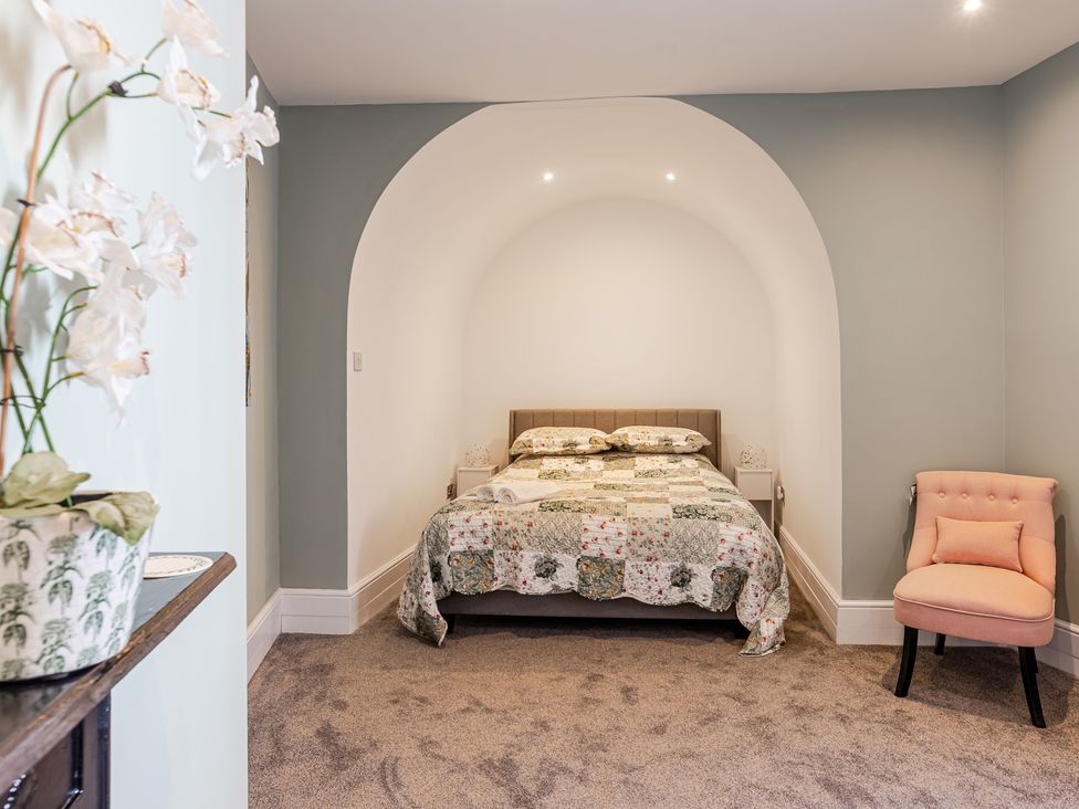 A bedroom with a bed and chair at Palm Villa in Torquay