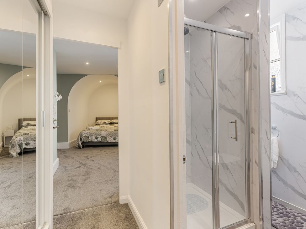 A bedroom showing a shower area and a bed at Palm Villa in Torquay