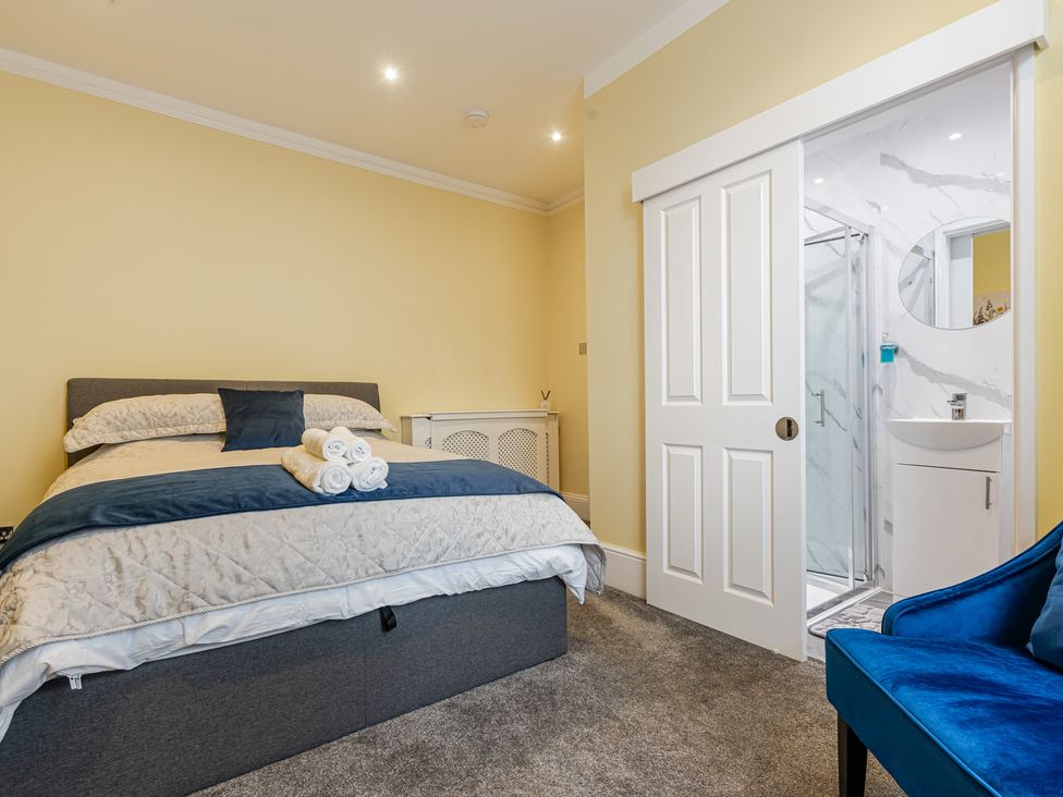 A bedroom with a bed and an ensuite bathroom at Palm Villa in Torquay