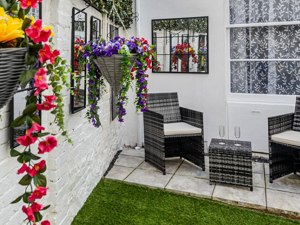 An outdoor seating area with chairs and table at Palm Villa in Torquay