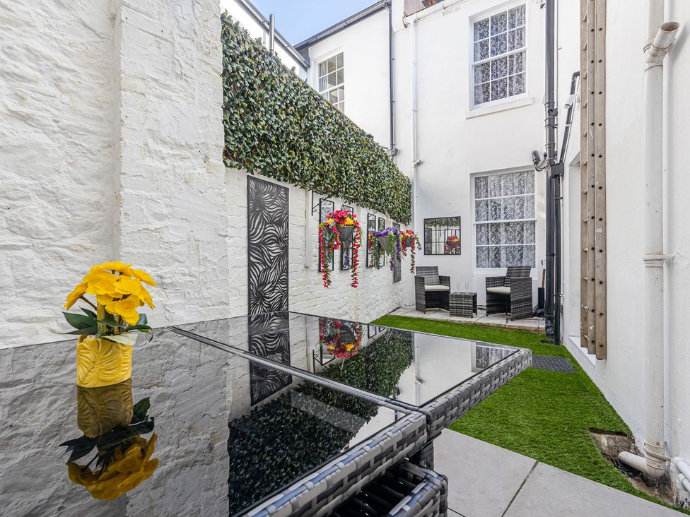 An outdoor area with a table and chairs at Palm Villa in Torquay
