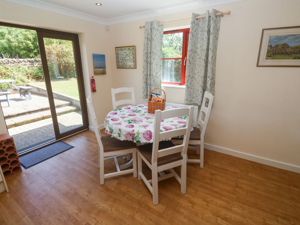 A dining room with a table and chairs at Yonde View in Camborne