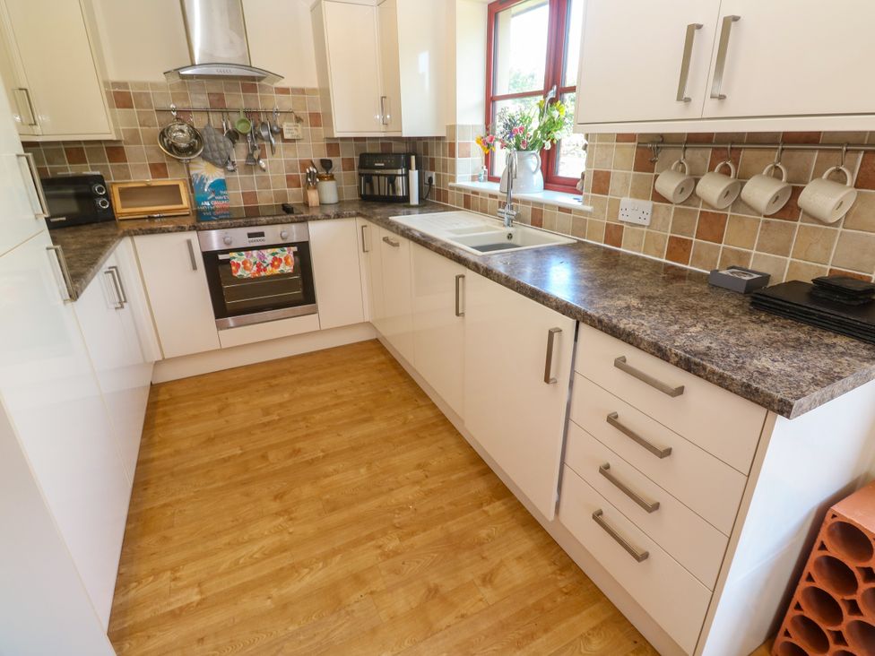 A kitchen with cabinets and appliances at Yonde View in Camborne
