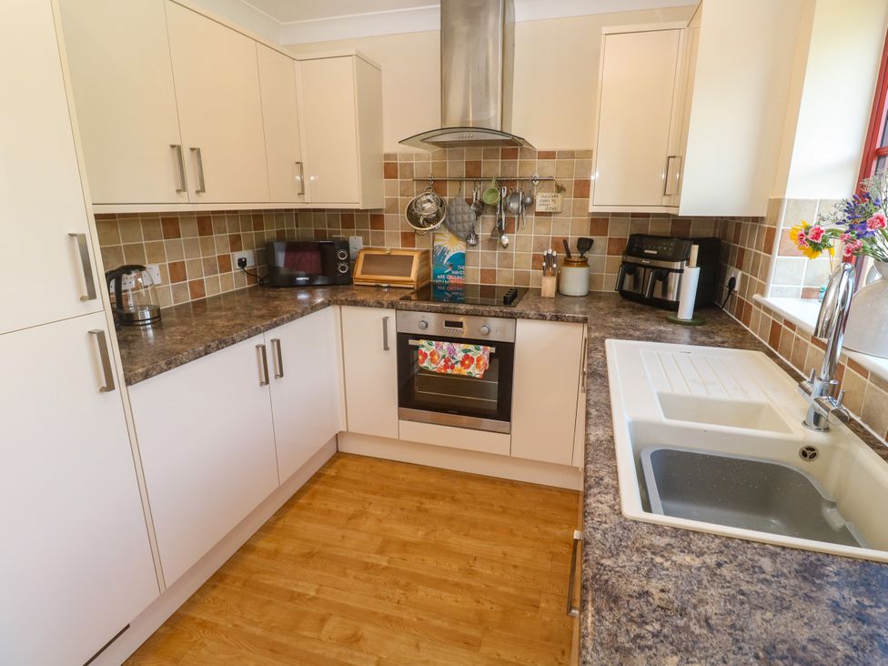 A kitchen with cabinets and appliances at Yonde View in Camborne