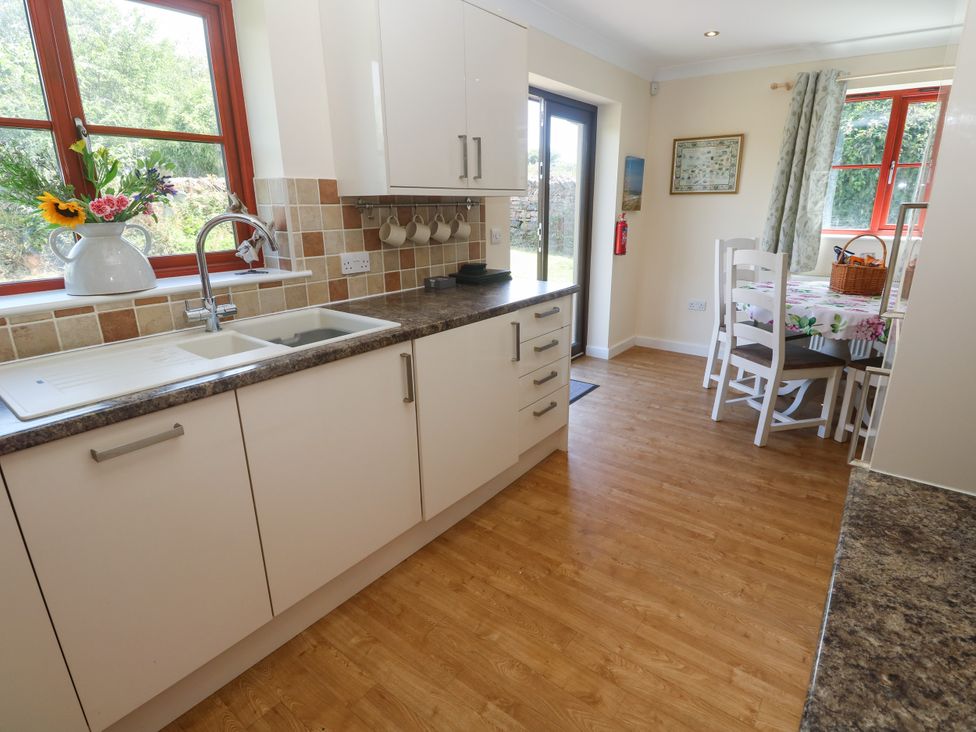 A kitchen with sink and dining area at Yonde View Camborne