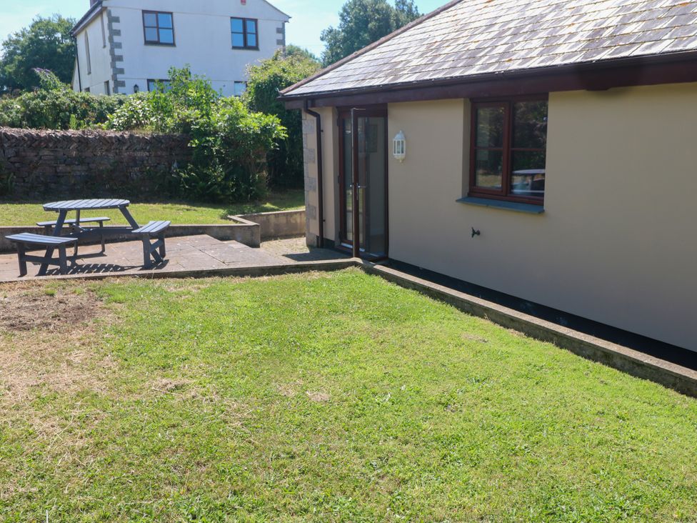 A garden with a table and bench at Yonde View in Camborne