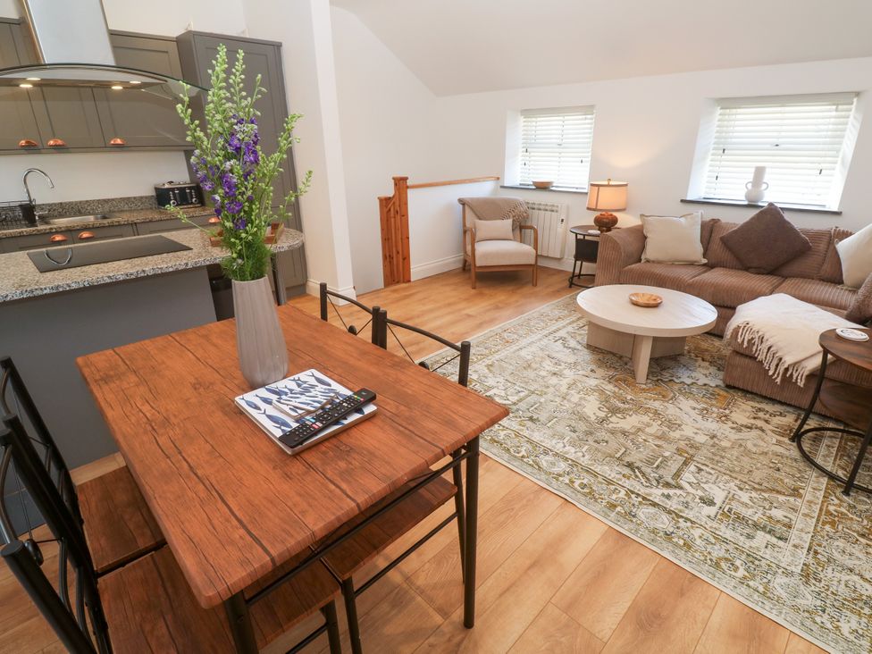 A living room with a coffee table, couch, and dining table at Gews Farm Lodge St Just