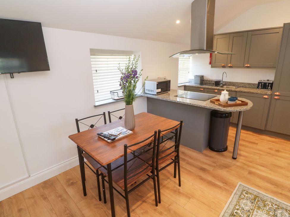 A kitchen with a dining table and chairs at Gews Farm Lodge in St Just