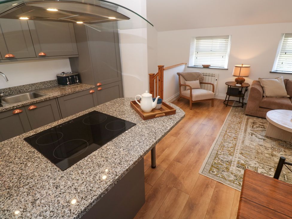 A kitchen area with countertop and armchair at Gews Farm Lodge St Just