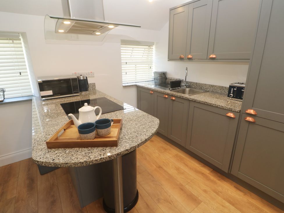 A kitchen with countertop, sink, and appliances at Gews Farm Lodge St Just