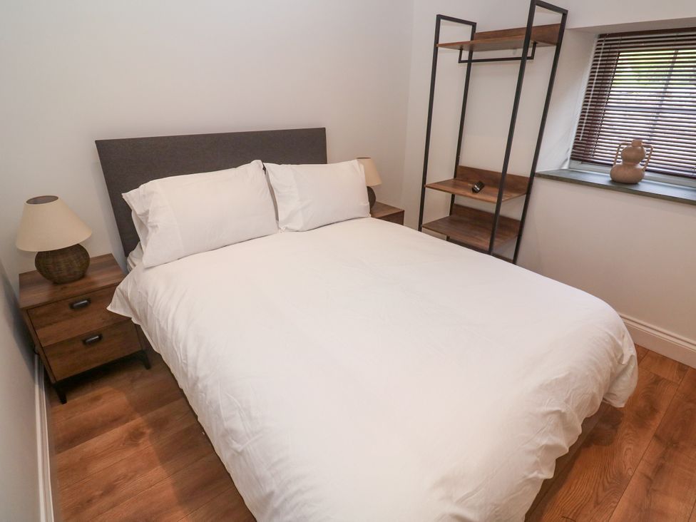 A bedroom with a bed and nightstands at Gews Farm Lodge, St Just